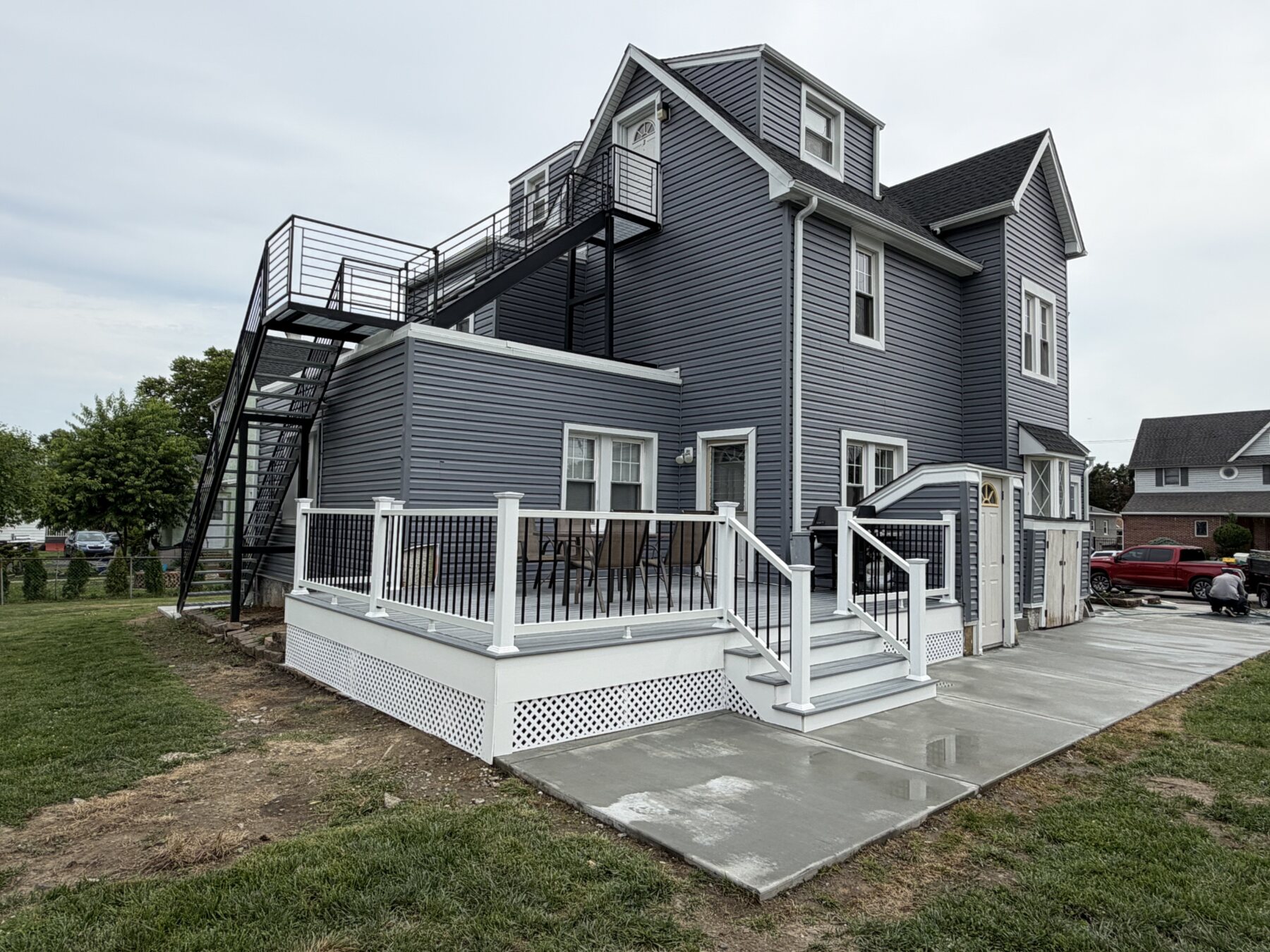 Gray home with completed deck and concrete project by MM Contractors